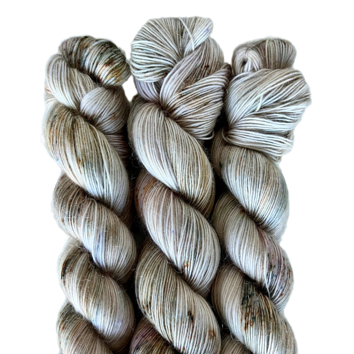 Three skeins of beige and brown yarn on a white background