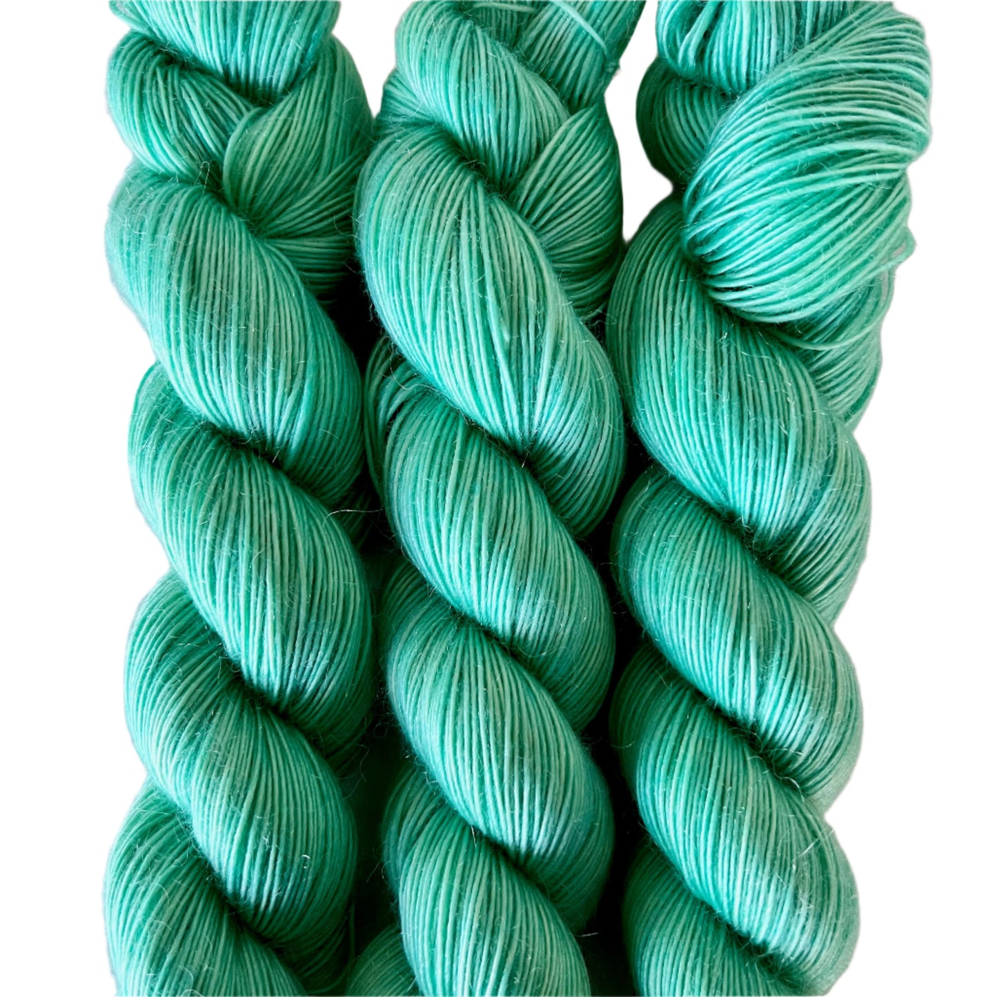 Three skeins of light green yarn on a white background