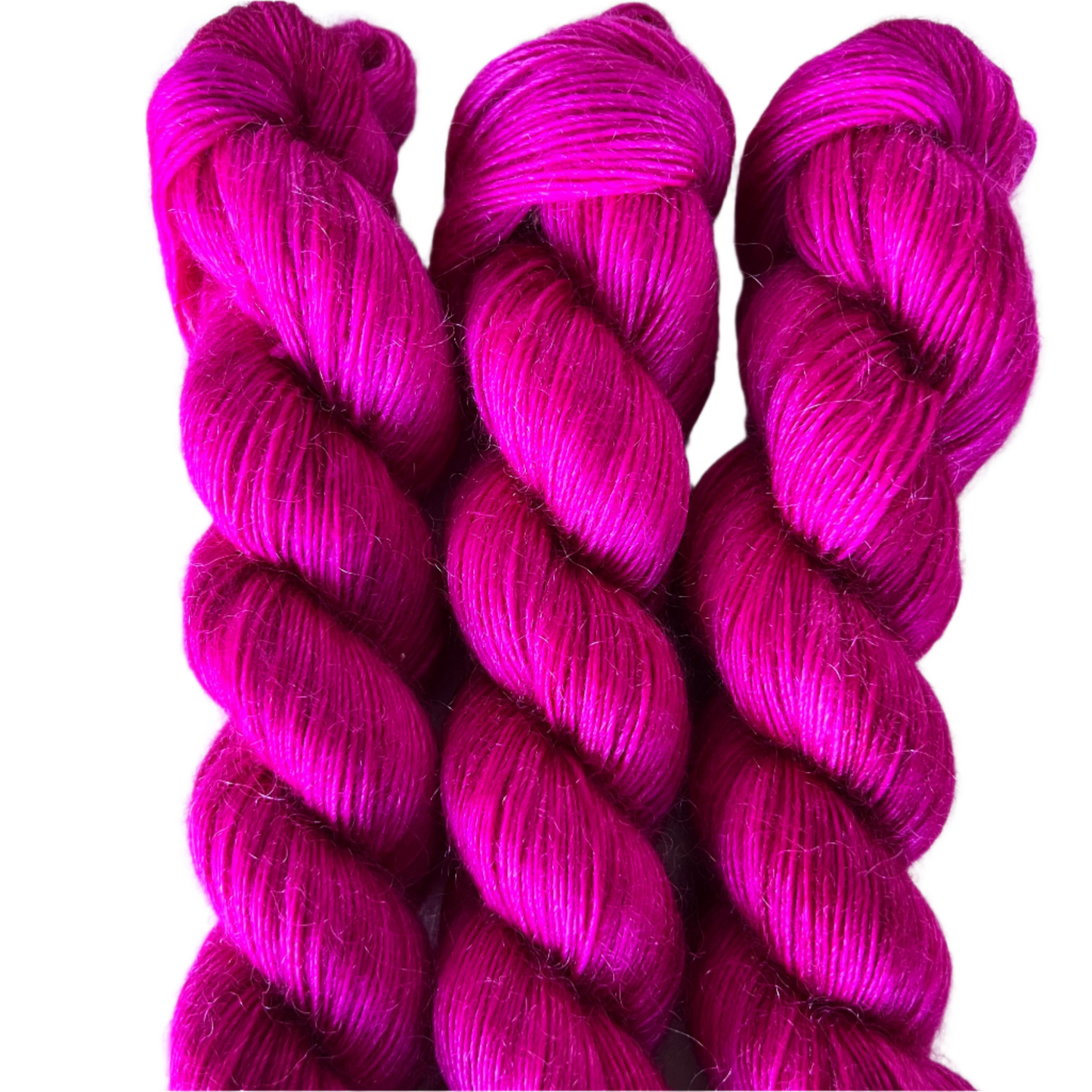 Three skeins of magenta pink yarn on a white background